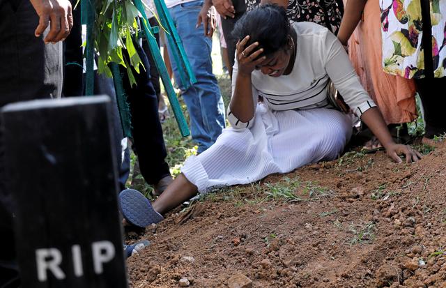 A woman reacts during a mass burial of victims, two days after a string of suicide bomb attacks on churches and luxury hotels across the island on Easter Sunday, in Colombo, Sri Lanka April 23, 2019. REUTERS/Dinuka Liyanawatte