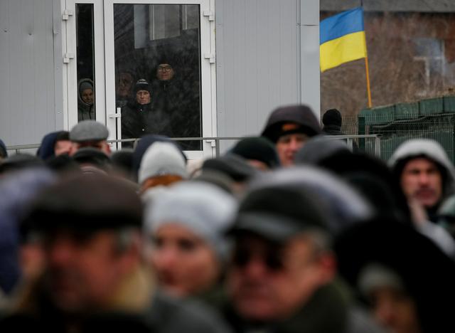 FILE PHOTO: People line up after crossing the contact line between pro-Moscow rebels and Ukrainian troops as they wait at passport control in Mayorsk, Ukraine February 25, 2019. REUTERS/Gleb Garanich/File Photo