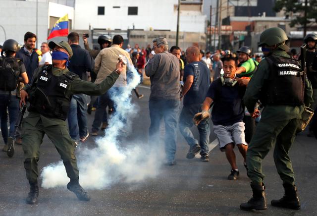 A military member throws a tear gas canister near the Generalisimo Francisco de Miranda Airbase La Carlota, in Caracas, Venezuela April 30, 2019. REUTERS/Carlos Garcia Rawlins