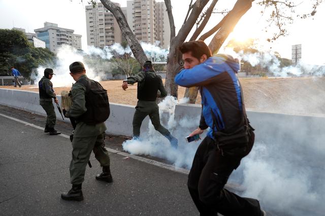 Military members react to tear gas, near the Generalisimo Francisco de Miranda Airbase La Carlota, in Caracas, Venezuela April 30, 2019. REUTERS/Carlos Garcia Rawlins