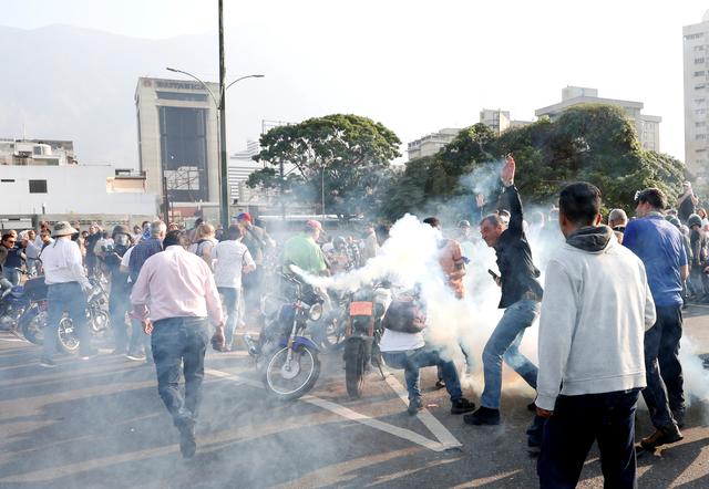 People react to tear gas near the Generalisimo Francisco de Miranda Airbase La Carlota, in Caracas, Venezuela April 30, 2019. REUTERS/Carlos Garcia Rawlins