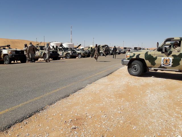 FILE PHOTO: Members of forces loyal to Libyan military commander Khalifa Haftar are seen with military vehicles near Libya's El Sharara oilfield in Obari,Libya,  February 11, 2019.   REUTERS/Stringer  