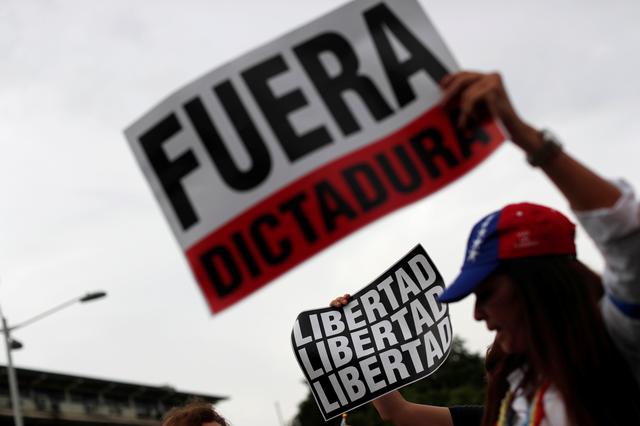 Supporters of Venezuelan opposition leader Juan Guaido, who many nations have recognized as the country's rightful interim ruler, take part in a protest in Panama City, Panama April 30, 2019. Placards reads Freedom, Out Dictatorship REUTERS/Carlos Jasso