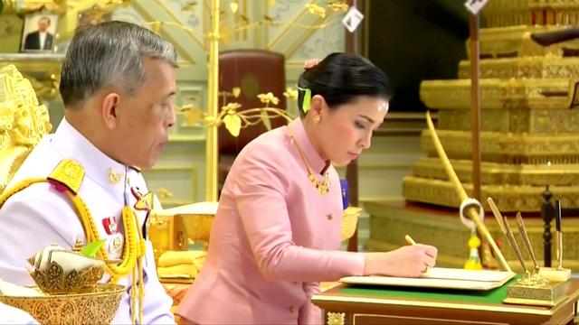 King Maha Vajiralongkorn and his consort, General Suthida Vajiralongkorn named Queen Suthida sign marriage documents during their wedding ceremony in Bangkok, Thailand May 1, 2019, in this screen grab taken from a video. Thai TV Pool  