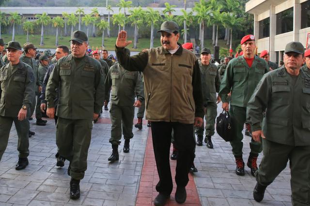 Venezuela's President Nicolas Maduro waves as he walks next to Venezuela's Defense Minister Vladimir Padrino Lopez and Remigio Ceballos, Strategic Operational Commander of the Bolivarian National Armed Forces, during a ceremony at a military base in Caracas, Venezuela May 2, 2019. Miraflores Palace/Handout via REUTERS 