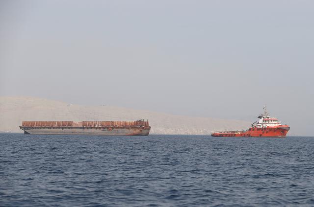 FILE PHOTO: A tugboat moves cargo towards the Strait of Hormuz off the coast of Musandam province, Oman, July 20, 2018. REUTERS/Hamad I Mohammed/File Photo
