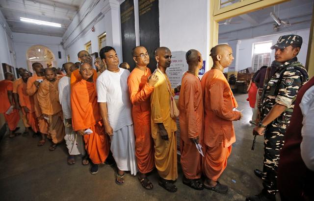 Hindu holy men stand in a queue inside a polling station to caste their vote during the final phase of general election in Kolkata, India, May 19, 2019. REUTERS/Rupak De Chowdhuri