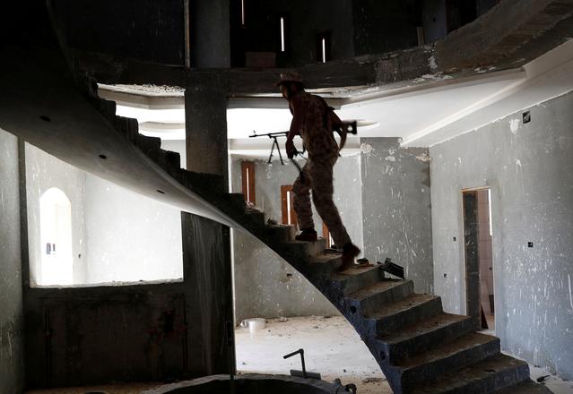 FILE PHOTO: A fighter loyal to Libyan internationally recognised government walks inside a building at outskirts of Tripoli, Libya May 16, 2019. REUTERS/Goran Tomasevic/File Photo
