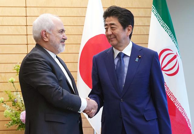 FILE PHOTO: Iranian Foreign Minister Mohammad Javad Zarif, left, and Japanese Prime Minister Shinzo Abe, right, shake hands at Abe's official residence in Tokyo Thursday, May 16, 2019. Eugene Hoshiko/Pool via REUTERS