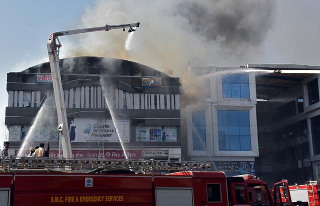 FILE PHOTO: Firefighters douse a fire that broke out in a four-story commercial building in Surat, in the western state of Gujarat, India, May 24, 2019. REUTERS/Stringer 