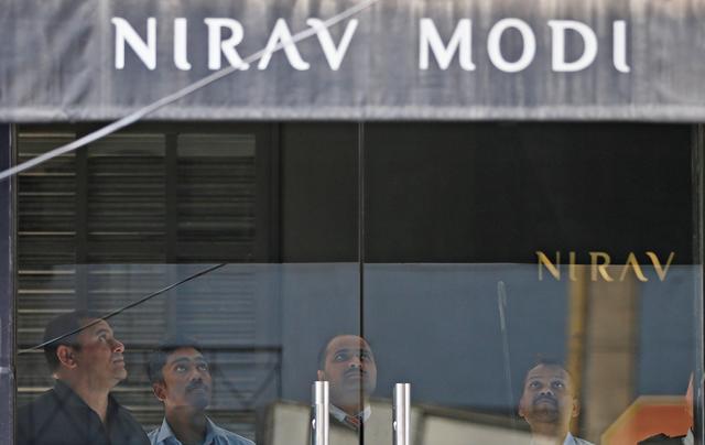 FILE PHOTO: Security guards stand inside a Nirav Modi showroom during a raid by the Enforcement Directorate, a government agency that fights financial crime, in New Delhi, India, February 15, 2018. REUTERS/Adnan Abidi