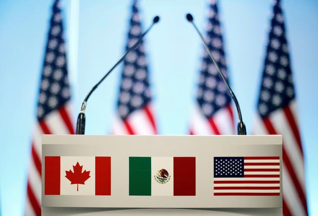FILE PHOTO: The flags of Canada, Mexico and the U.S. are seen on a lectern before a joint news conference on the closing of the seventh round of NAFTA talks in Mexico City, Mexico March 5, 2018. REUTERS/Edgard Garrido/File Photo