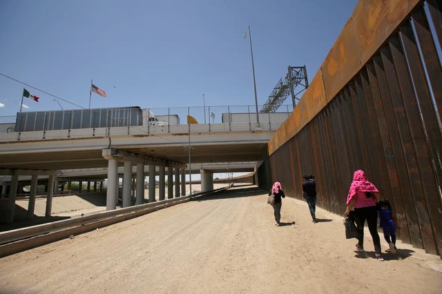 A group of Central American migrants walk next to the U.S.-Mexico border fence after they crossed the borderline in El Paso, Texas, U.S May 15, 2019. REUTERS/Jose Luis Gonzalez