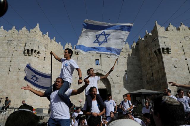 Jewish youth wave Israeli flags as they participate in a march marking Jerusalem Day, near Damascus Gate in Jerusalem's Old City June 2, 2019. REUTERS/Ammar Awad 