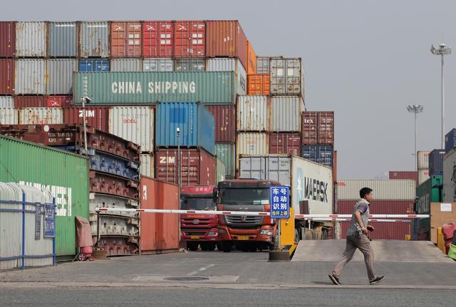 A man walks next to containers in a logistics center near Tianjin Port, in northern China, May 16, 2019. REUTERS/Jason Lee