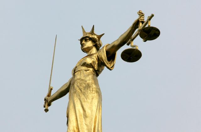 FILE PHOTO: A statue representing the scales of justice is seen on the roof of the Old Bailey courts in central London, January 26, 2007. REUTERS/Toby Melville/File Photo