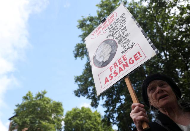 A demonstrator holding a placard protests outside of Westminster Magistrates Court, where a case hearing for U.S. extradition of Wikileaks founder Julian Assange is held, in London, Britain, June 14, 2019. REUTERS/Hannah Mckay - RC17C61BCDA0