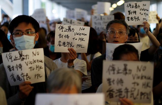 Protesters hold signs following a day of violence over a proposed extradition bill, outside the Legislative Council building in Hong Kong, China, June 13, 2019. REUTERS/Jorge Silva