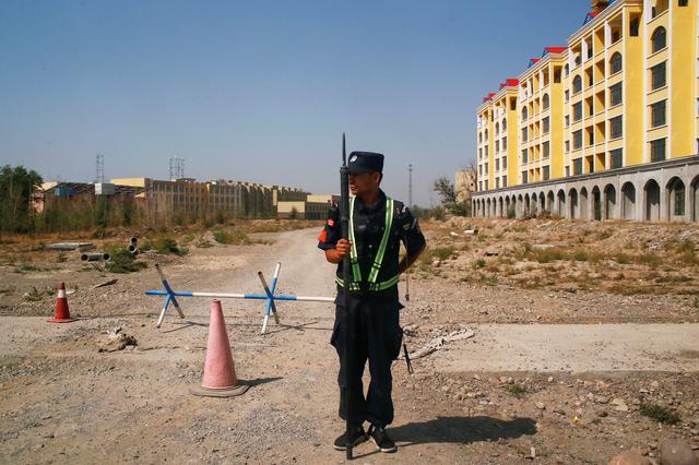 FILE PHOTO: A Chinese police officer takes his position by the road near what is officially called a vocational education centre in Yining in Xinjiang Uighur Autonomous Region, China September 4, 2018. REUTERS/Thomas Peter/File Photo