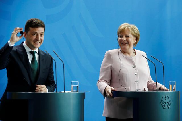 German Chancellor Angela Merkel and Ukrainian President Zelenskiy react during a news conference in Berlin, Germany, June 18, 2019. REUTERS/Hannibal Hanschke