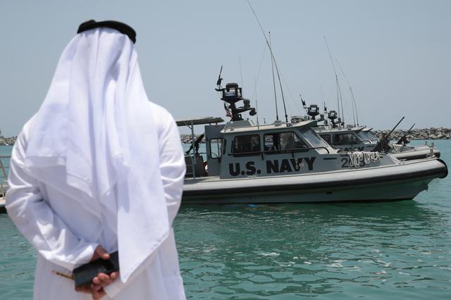 An Emirati official watches members of the U.S. Navy Fifth Fleet as they prepare to escort journalists to the Japanese-owned Kokuka Courageous tanker at a U.S. NAVCENT facility near the port of Fujairah, United Arab Emirates June 19, 2019. REUTERS/Christopher Pike