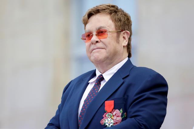FILE PHOTO: Elton John listens in the courtyard of the presidential Elysee Palace in Paris, France June 21, 2019. Lewis Joly/Pool via REUTERS/File Photo