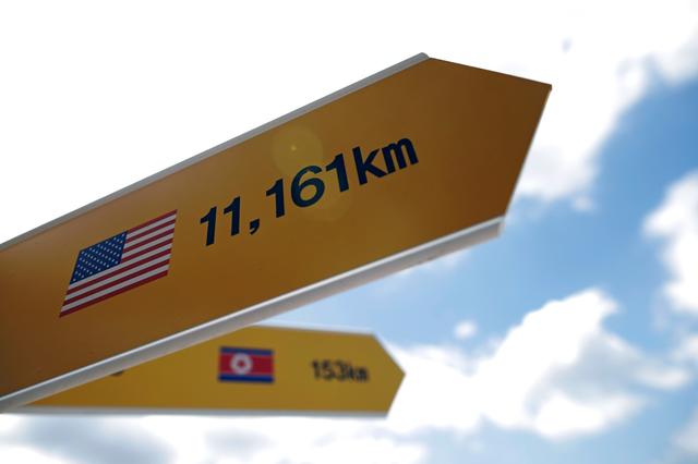 Directional signs bearing North Korean and U.S. flags are seen near the demilitarized zone in Paju, South Korea, June 12, 2018.   REUTERS/Kim Hong-Ji