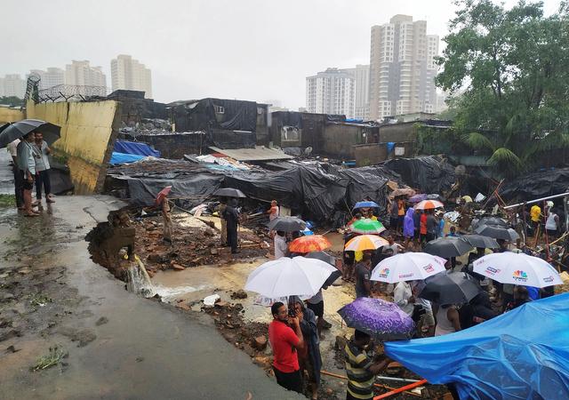 People stand among the debris after a wall collpased on hutments due to heavy rains in Mumbai, India July 2, 2019. REUTERS/Prashant Waydande