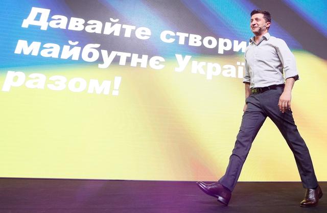 FILE PHOTO: Ukraine's President Volodymyr Zelenskiy walks on the stage at an IT conference in Kiev, Ukraine May 23, 2019. The sign on a screen reads Let's create the future of Ukraine together! REUTERS/Valentyn Ogirenko/File Photo