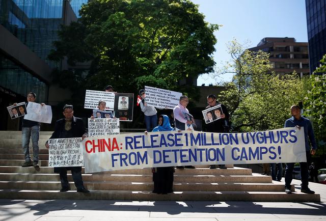 FILE PHOTO: People hold signs protesting China's treatment of the Uighur people, in Vancouver, British Columbia, Canada, May 8, 2019. REUTERS/Lindsey Wasson