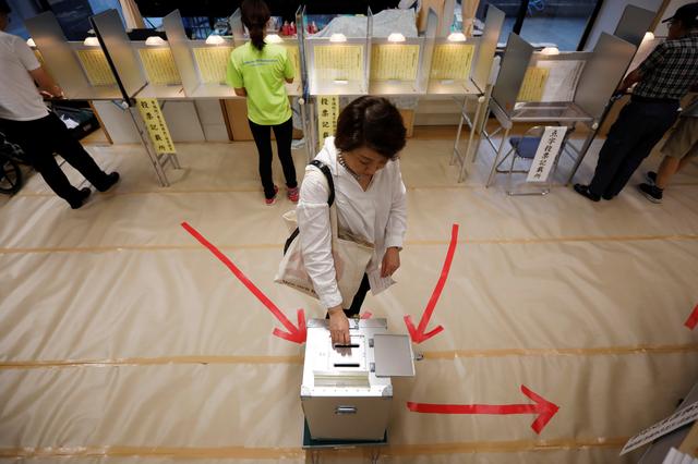 A voter casts a ballot at a voting station during Japan's upper house election in Tokyo, Japan July 21, 2019. REUTERS/Issei Kato
