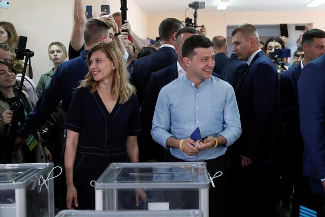 Ukraine's President Volodymyr Zelenskiy and his wife Olena stand in front of ballot boxes at a polling station during a parliamentary election in Kiev, Ukraine July 21, 2019. REUTERS/Valentyn Ogirenko