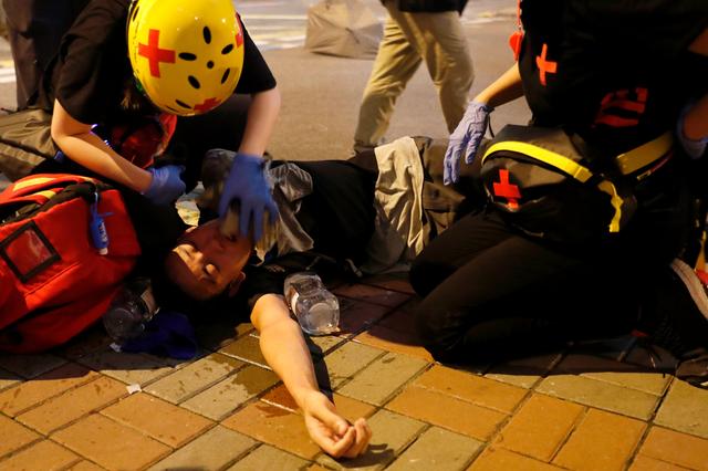 An anti-extradition bill demonstrator receives medical attention after riot police fire tear gas after a march to call for democratic reforms, in Hong Kong, China July 21, 2019. REUTERS/Tyrone Siu