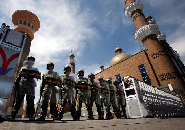 FILE PHOTO: Chinese paramilitary police in riot gear stand guard across the entrance to a large mosque in the centre of the city of Urumqi in China's Xinjiang Autonomous Region July 9, 2009.  REUTERS/David Gray/File Photo