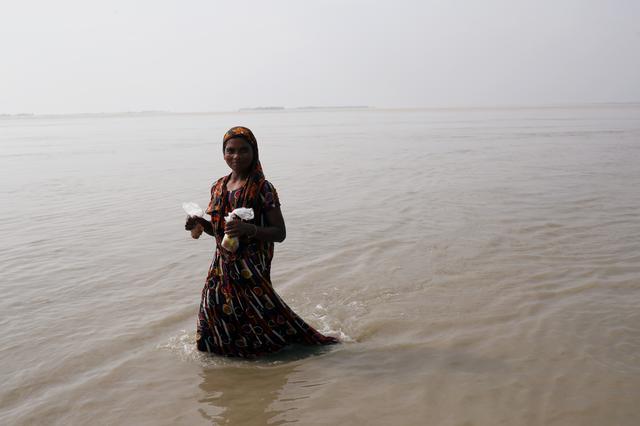 A flood-affected woman wades through flooded area in Jamalpur, Bangladesh July 21, 2019. REUTERS/Mohammad Ponir Hossain