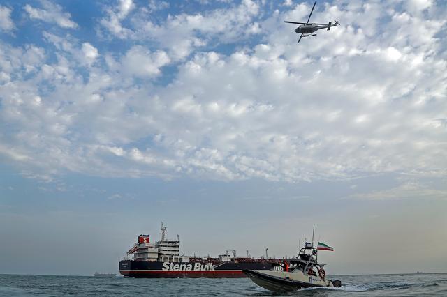 FILE PHOTO - A boat of the Iranian Revolutionary Guard sails next to Stena Impero, a British-flagged vessel owned by Stena Bulk, at Bandar Abbas port, July 21, 2019. Picture taken July 21, 2019. Iran, Mizan News Agency/WANA Handout via REUTERS 