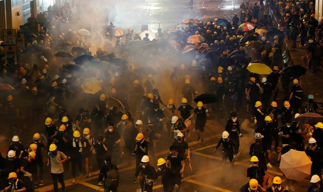 FILE PHOTO: Anti-extradition demonstrators run from tear gas after a march of to call for democratic reforms, in Hong Kong, China July 21, 2019. REUTERS/Tyrone Siu/File Photo