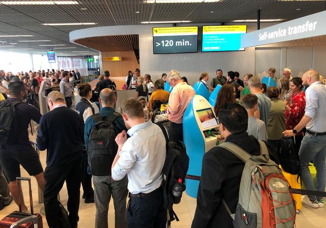 Passengers and staff wait at Amsterdam Schiphol airport during an outage at the airport's main fuel supplier that kept dozens of flights on the ground, in Amsterdam, Netherlands July 24, 2019.  REUTERS/Anthony Deutsch