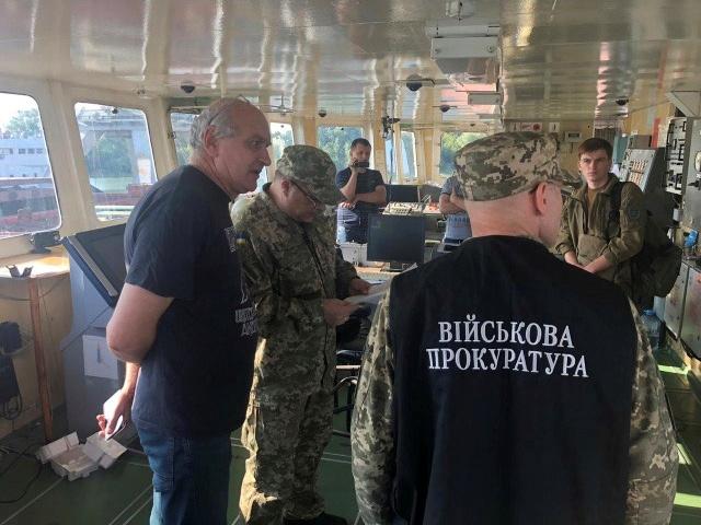 Officers of the Ukrainian security services surround a crew member (L) of the Russian tanker, now called Nika Spirit and formerly named Neyma, which was detained in the port of Izmail, Ukraine in this handout picture obtained by Reuters on July 25, 2019. Military Prosecutor's Office of the Southern Region of Ukraine/Handout via REUTERS  