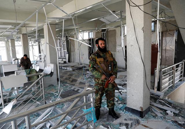 A guard of Afghan security forces inspects a damaged building at the site of a blast in Kabul, Afghanistan July 25, 2019. REUTERS/Mohammad Ismail