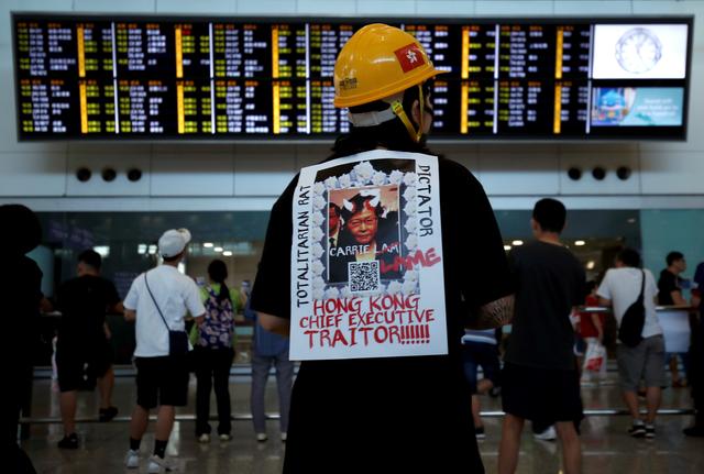 A demonstrator wears a placard during a protest against the recent violence in Yuen Long, at Hong Kong airport, China July 26, 2019. REUTERS/Edgar Su