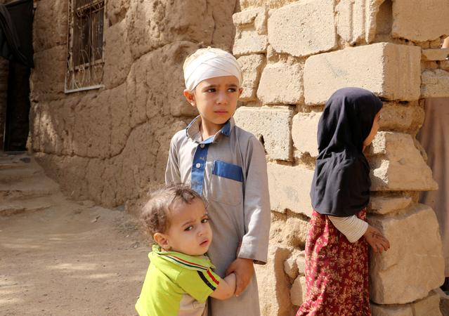 FILE PHOTO: Mukhtar Hadi, who survived survived last month's Saudi-led air strike that killed dozens including children, stands with his brother and sister in Saada, Yemen September 4, 2018. Picture taken September 4, 2018. REUTERS/Naif Rahma/File Photo