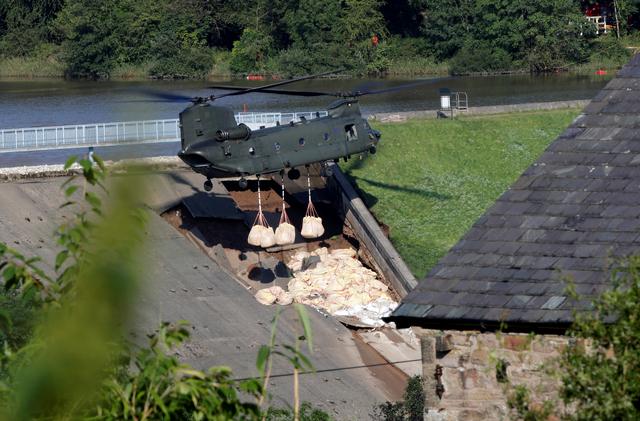 A Chinook helicopter drops sand bags on top of the dam after a nearby reservoir was damaged by flooding, in Whaley Bridge, Britain August 2, 2019. REUTERS/Phil Noble