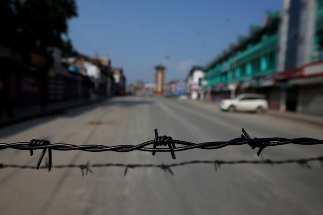 Barbed wire is seen laid on a deserted road during restrictions in Srinagar, August 5, 2019. REUTERS/Danish Ismail