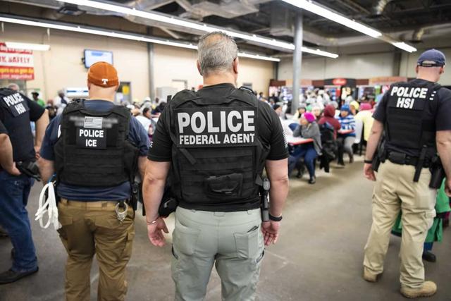 FILE PHOTO: Officers from Immigration and Customs Enforcement (ICE) look on after executing search warrants and making some arrests at an agricultural processing facility in Canton, Mississippi, U.S. in this August 7, 2019 handout photo.    Immigration and Customs Enforcement/Handout via REUTERS 