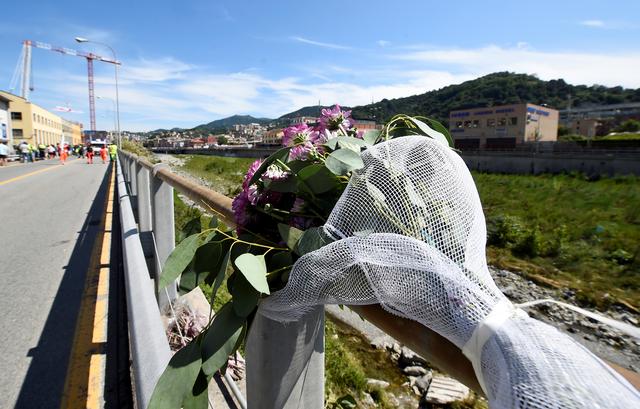 Flowers lay on the motorway traffic barrier after the ceremonies marking the first anniversary of the collapse of a motorway Morandi Bridge that killed 43 people in Genoa, Italy, August 14, 2019. REUTERS/Massimo Pinca