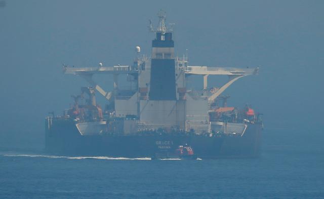 A boat sails after approaching to the boarding ladder (L) of the Iranian oil tanker Grace 1 as it sits anchored after it was seized in July by British Royal Marines off the coast of the British Mediterranean territory on suspicion of violating sanctions against Syria, in the Strait of Gibraltar, southern Spain August 14, 2019. REUTERS/Jon Nazca