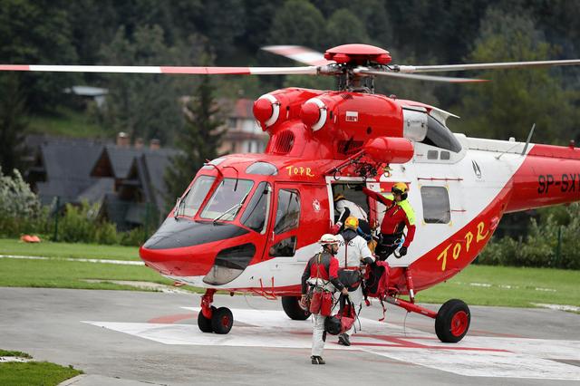 Mountain rescue team (TOPR) members board a helicopter in Zakopane, Poland August 18, 2019, to join the search operation for two cave climbers trapped in the Tatra mountains.  Agencja Gazeta/Marek Podmokly via REUTERS ATTENTION EDITORS - THIS IMAGE WAS PROVIDED BY A THIRD PARTY. POLAND OUT NO COMMERCIAL OR EDITORIAL SALES IN POLAND
