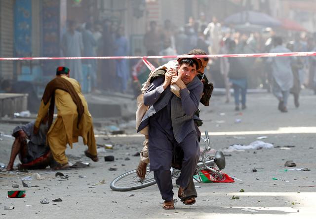 A man caries a wounded person to the hospital after a blast in Jalalabad, Afghanistan August 19, 2019. REUTERS/Parwiz