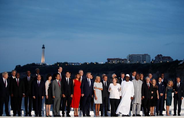 French President Emmanuel Macron, U.S. President Donald Trump, Japan's Prime Minister Shinzo Abe, Britain's Prime Minister Boris Johnson, German Chancellor Angela Merkel, Canada's Prime Minister Justin Trudeau and Italy's acting Prime Minister Giuseppe Conte pose for a family photo with invited guests during the G7 summit in Biarritz, France, August 25, 2019. REUTERS/Christian Hartmann/Pool